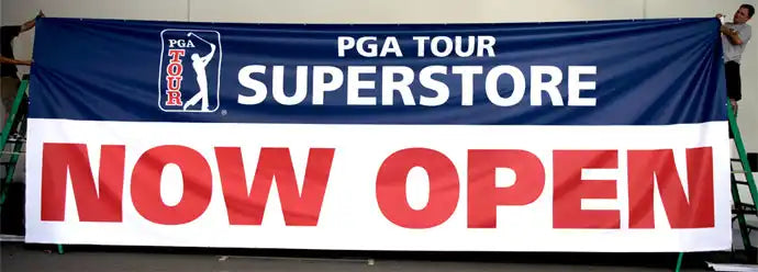 Blue and white banner announcing a PGA Tour Superstore opening with ’NOW OPEN’ text in red.